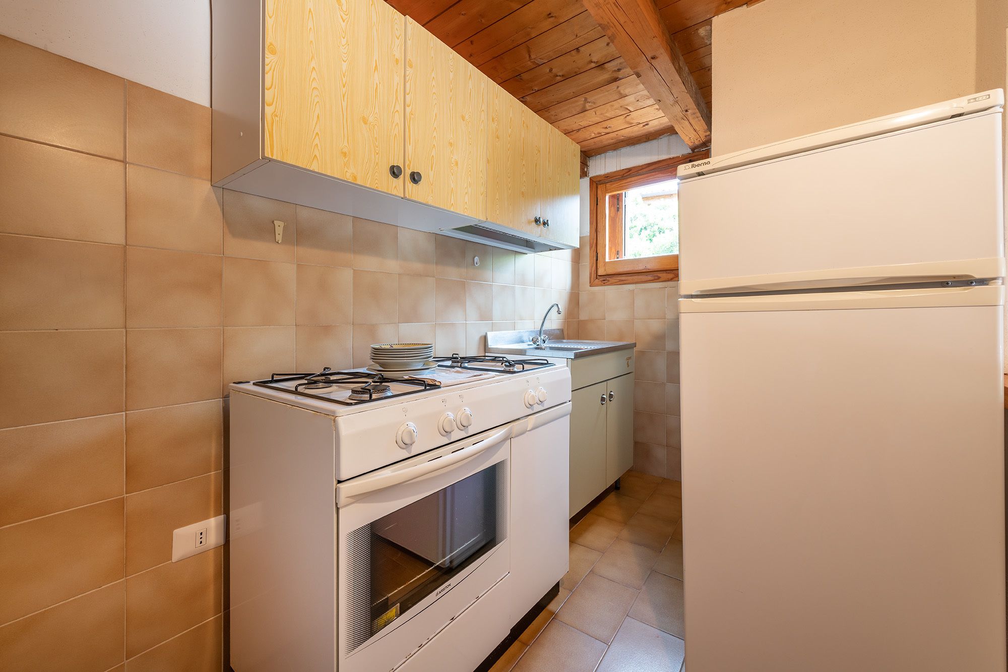 A kitchen with a gas stove, oven, and a white refrigerator.