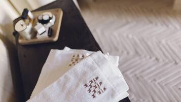 A wooden tray with a coffee maker and a cup on a dark surface.