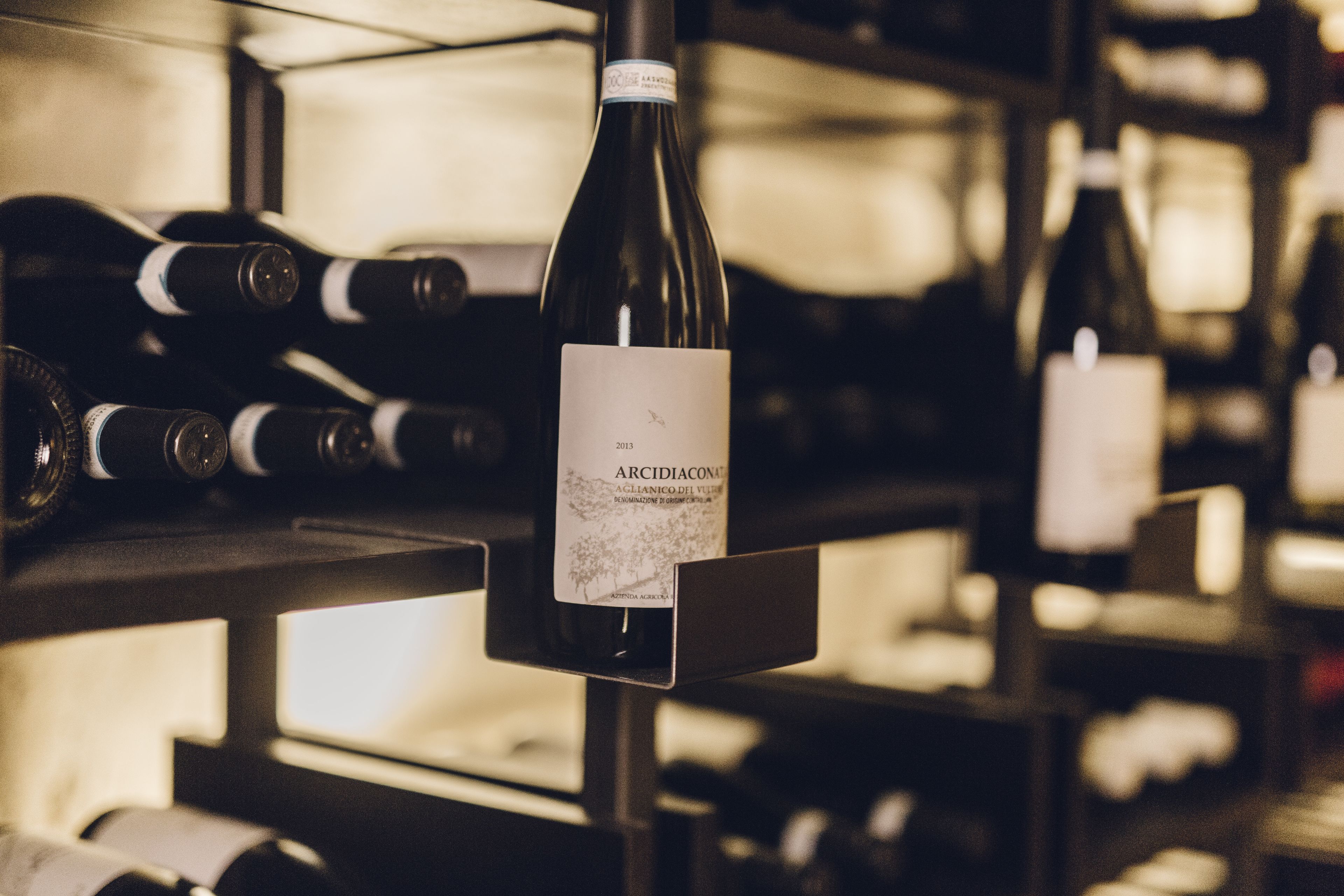 Une bouteille de vin, avec son étiquette, dans un présentoir à vin.