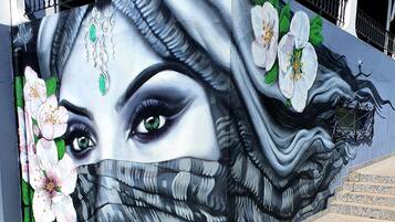 A mural with floral and abstract designs on a building facade.