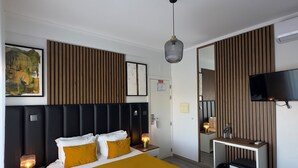 A modern hotel room with a large bed, bedside tables, a desk, a mirror, and a flat-screen TV. - Hotel Don Rodrigues (Tavira)