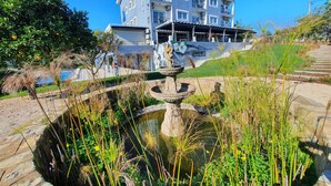A hotel with a pool, surrounded by greenery and a fountain. - Hotel Don Rodrigues (Tavira)