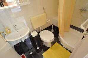 A small bathroom with a sink, toilet, and bathtub.