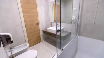 Une salle de bain moderne avec une douche à parois de verre, une porte en bois et un lavabo blanc.