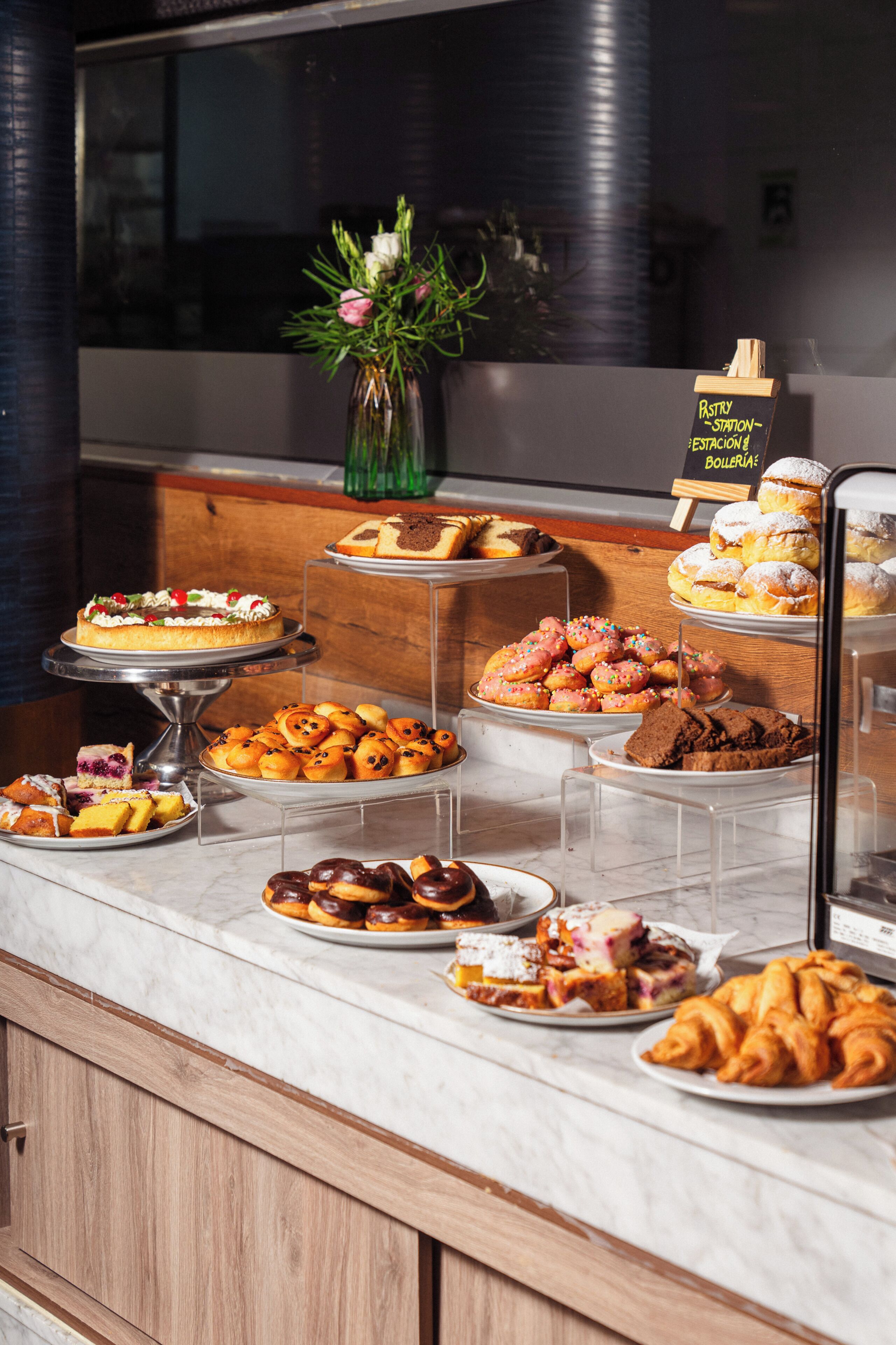 Una vitrina de pastelería con diversos pasteles y postres.