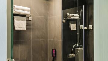 Un baño moderno con cabina de ducha de vidrio, una bañera independiente y un inodoro.