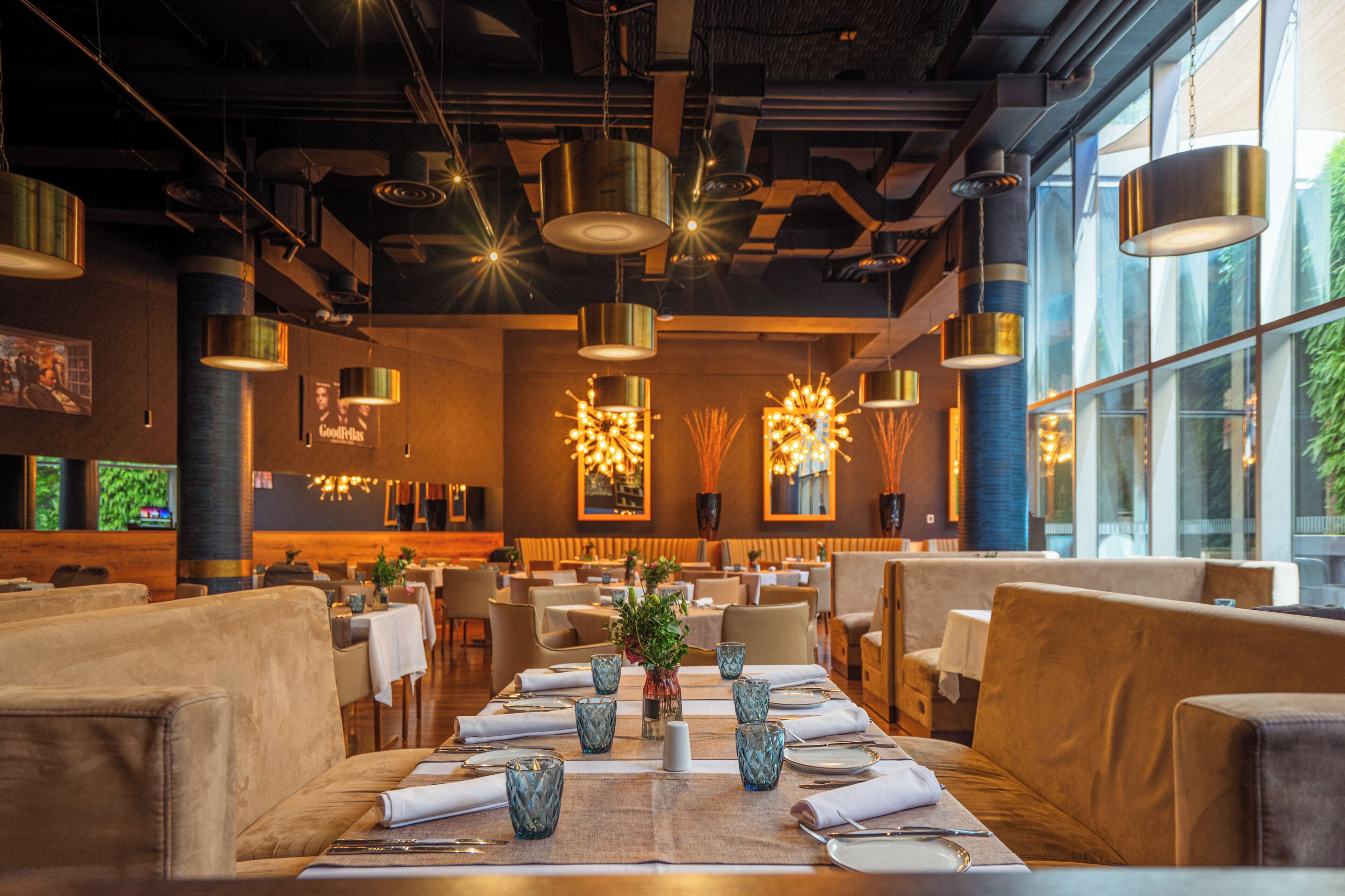A restaurant with a long dining table set for a meal, surrounded by chairs.