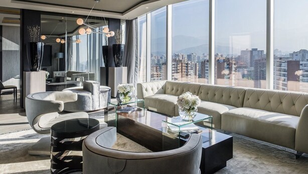 Uma sala de estar moderna com uma janela grande, um sofá, uma mesa de centro e uma cadeira de design exclusivo.