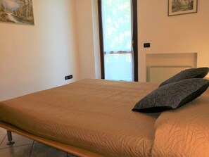 Une chambre à coucher avec un lit, une fenêtre et deux tableaux accrochés au mur.