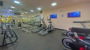 A gym with treadmills, weight machines, and a TV screen. - Hotel Decameron Marazul (San Andres)