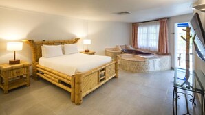 A room with a large bed, a small table, a bathtub, and a TV. - Hotel Decameron Marazul (San Andres)