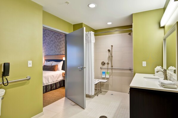 Une salle de bain d’hôtel équipée d’une douche, de toilettes et d’un lavabo.