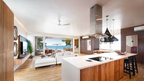 Una cocina moderna con una isla central, armarios de madera e iluminación colgante.