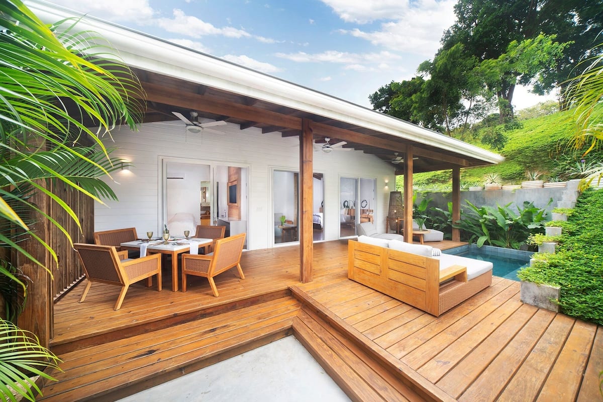 Eine moderne Terrassenausstattung mit Holzbelag, einer integrierten Sitzgelegenheit und einem Pool.