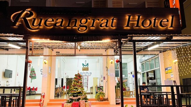 Rueangrat Hotel with a Christmas tree and presents outside.