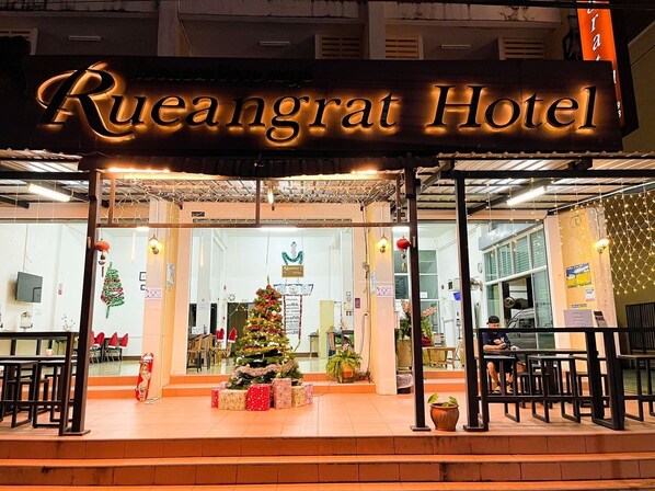 Rueangrat Hotel with a Christmas tree and presents outside.