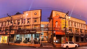 A hotel with a traditional facade, a Christmas tree outside, and a sign for the Rungrat Hotel.
