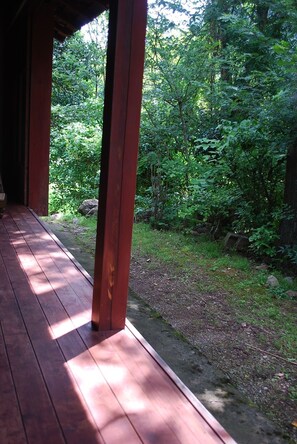 Una terraza de madera que da a un área boscosa con un ambiente natural y tranquilo.