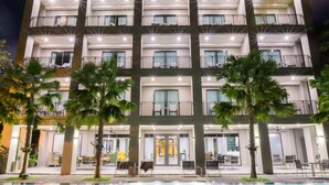 A multi-story hotel with balconies, a swimming pool, and outdoor seating areas. - The Sala Pattaya (Pattaya)