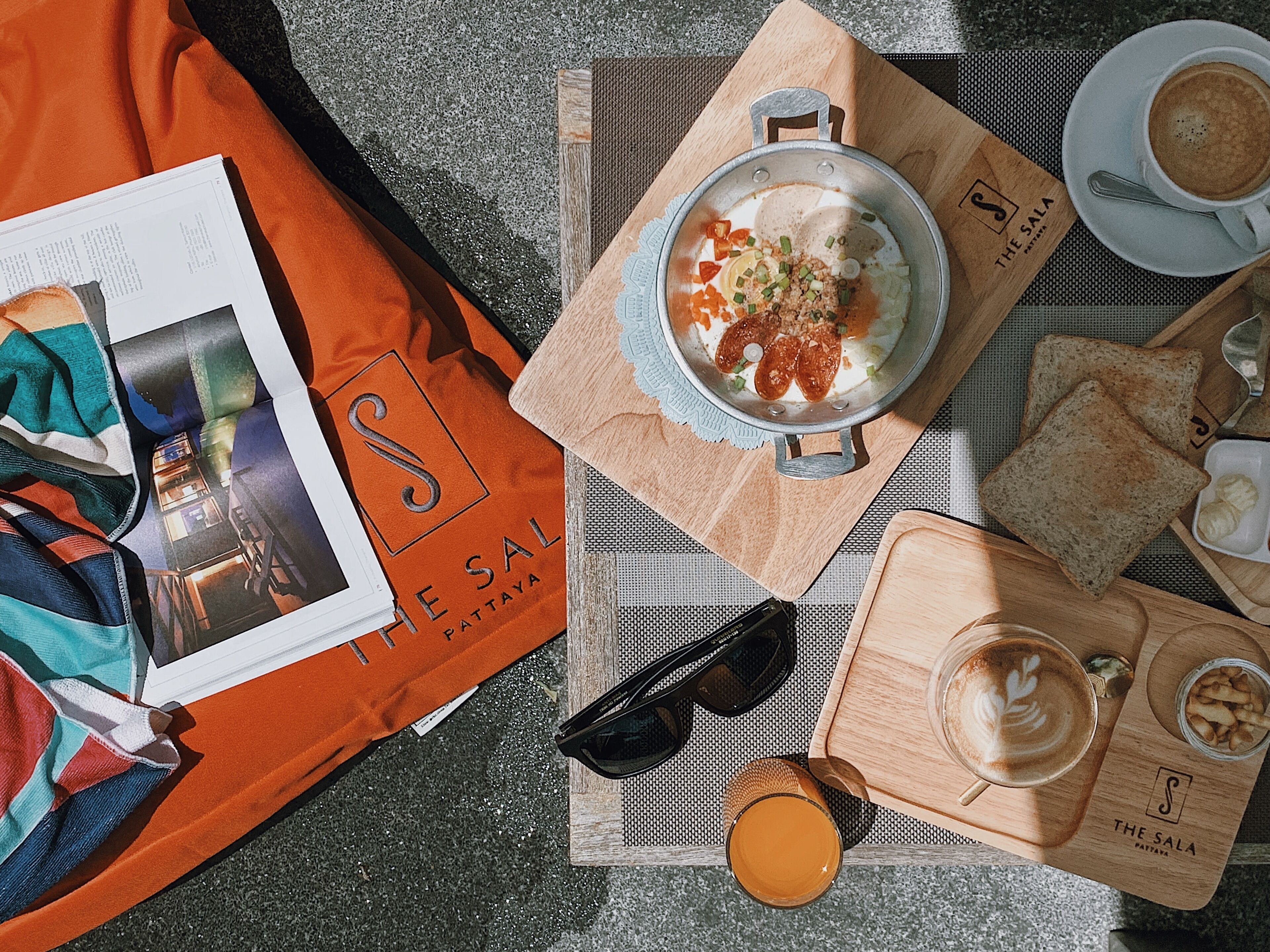 Ontbijt met een kom soep, toast, een kop koffie en een glas sinaasappelsap op een houten dienblad.