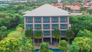 A multi-story hotel with balconies, a swimming pool, and lush greenery surrounding the property. - The Sala Pattaya (Pattaya)