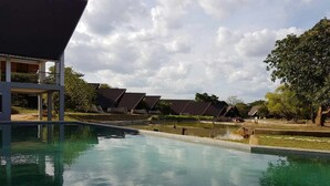 A swimming pool with a clear view of the surrounding buildings and landscape. - Liyya Water Villas (Dambulla)