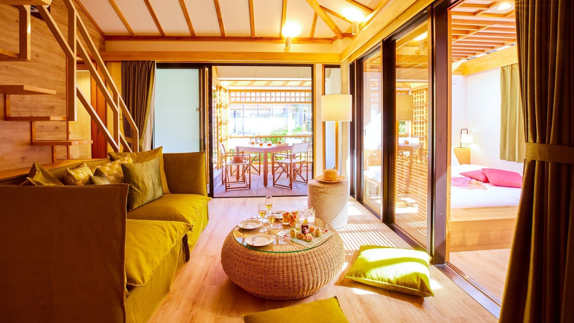 Un intérieur moderne avec un canapé, une table ronde sur laquelle se trouve de la nourriture, et une vue sur l’extérieur.