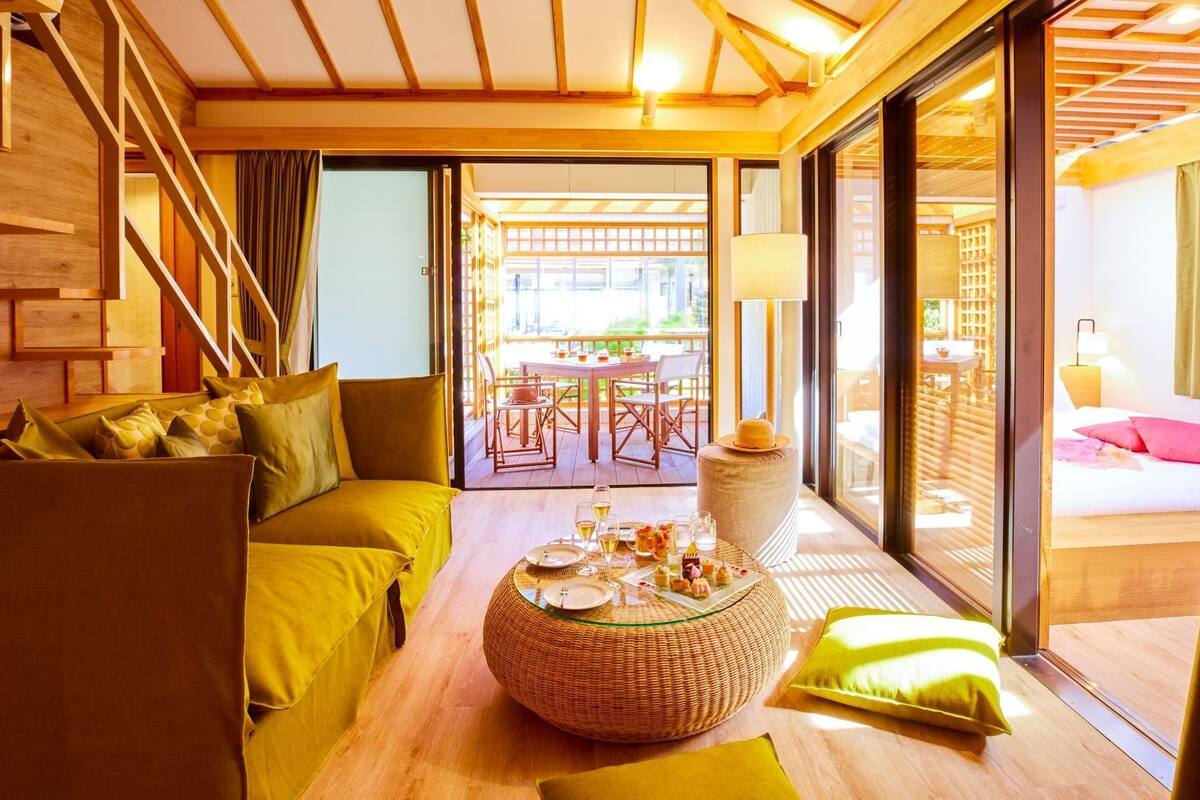 Ein modernes Interieur mit einer Couch, einem runden Tisch mit Speisen und Blick ins Freie.