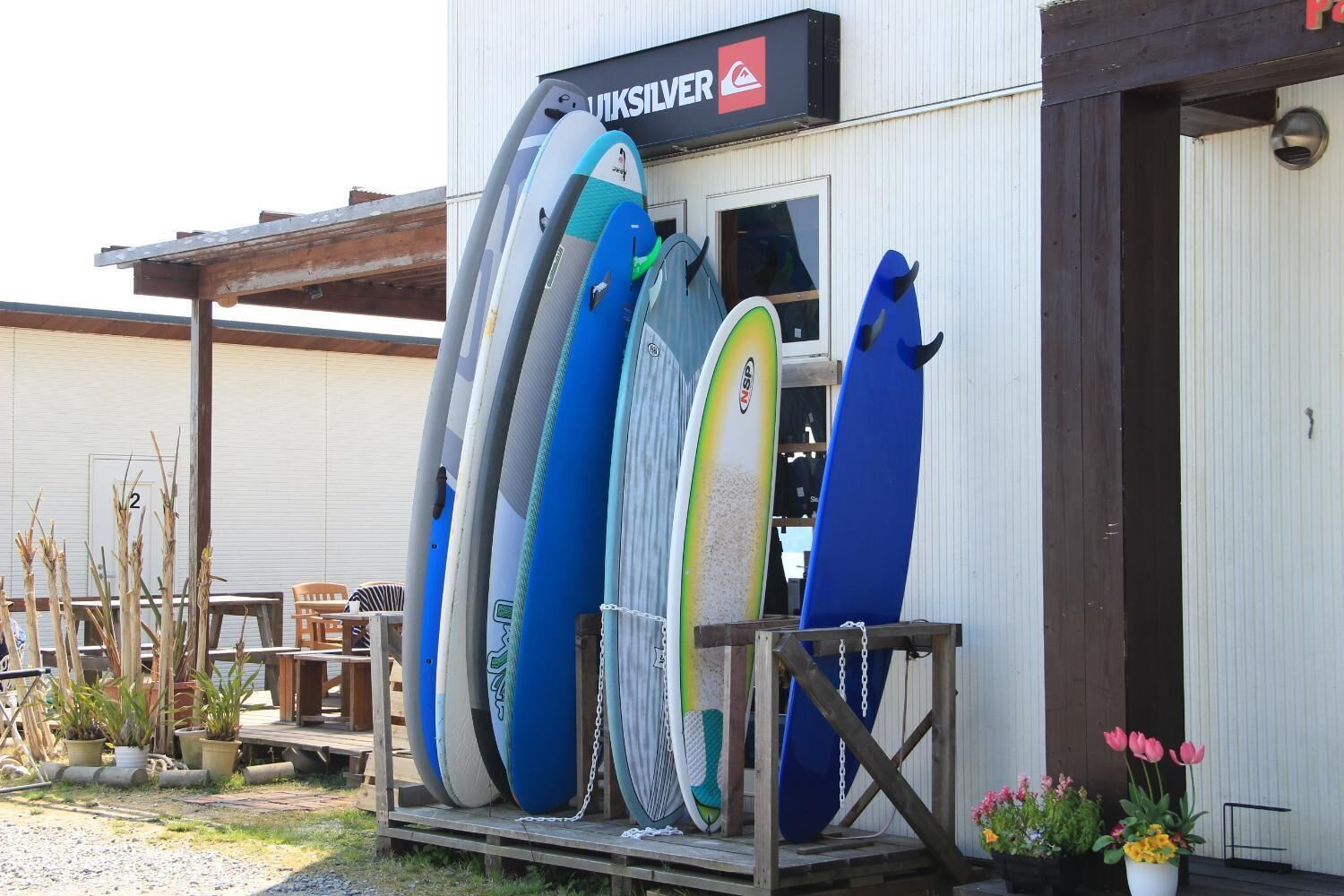 A surfboard rental shop with multiple surfboards on display outside.