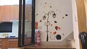 Una scala decorata da un adesivo murale raffigurante un albero e cuori.