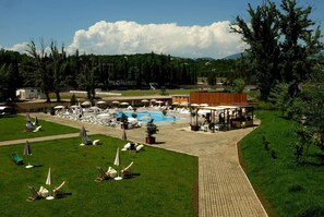 Ein Resort mit Schwimmbad, Liegestühlen und einer überdachten Sitzgruppe.