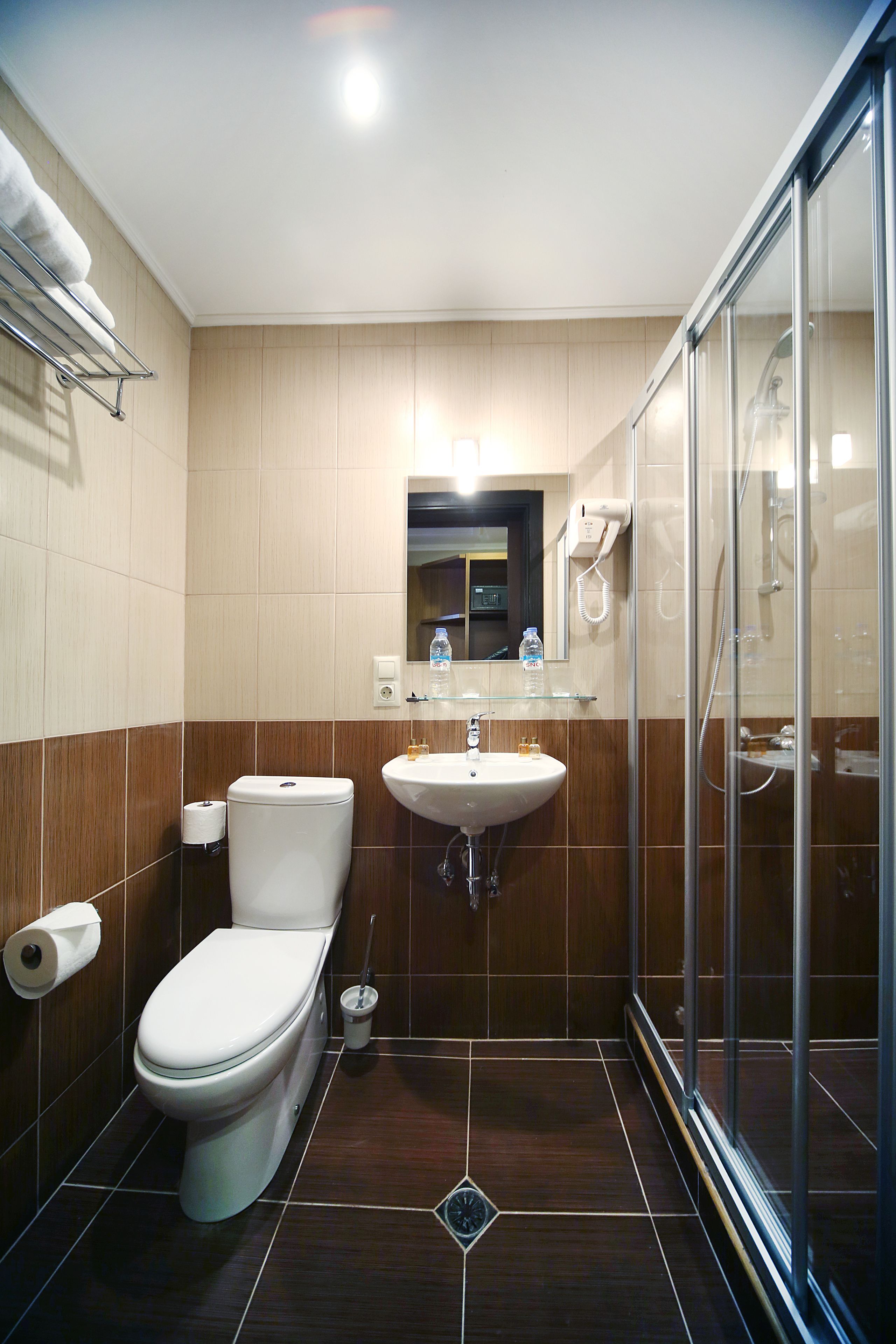 A modern bathroom with a toilet, sink, and glass shower enclosure.