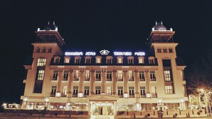 Un grand hôtel à plusieurs étages, reconnaissable à son enseigne bien visible indiquant « TSKALTUBO PLAZA HOTEL ».