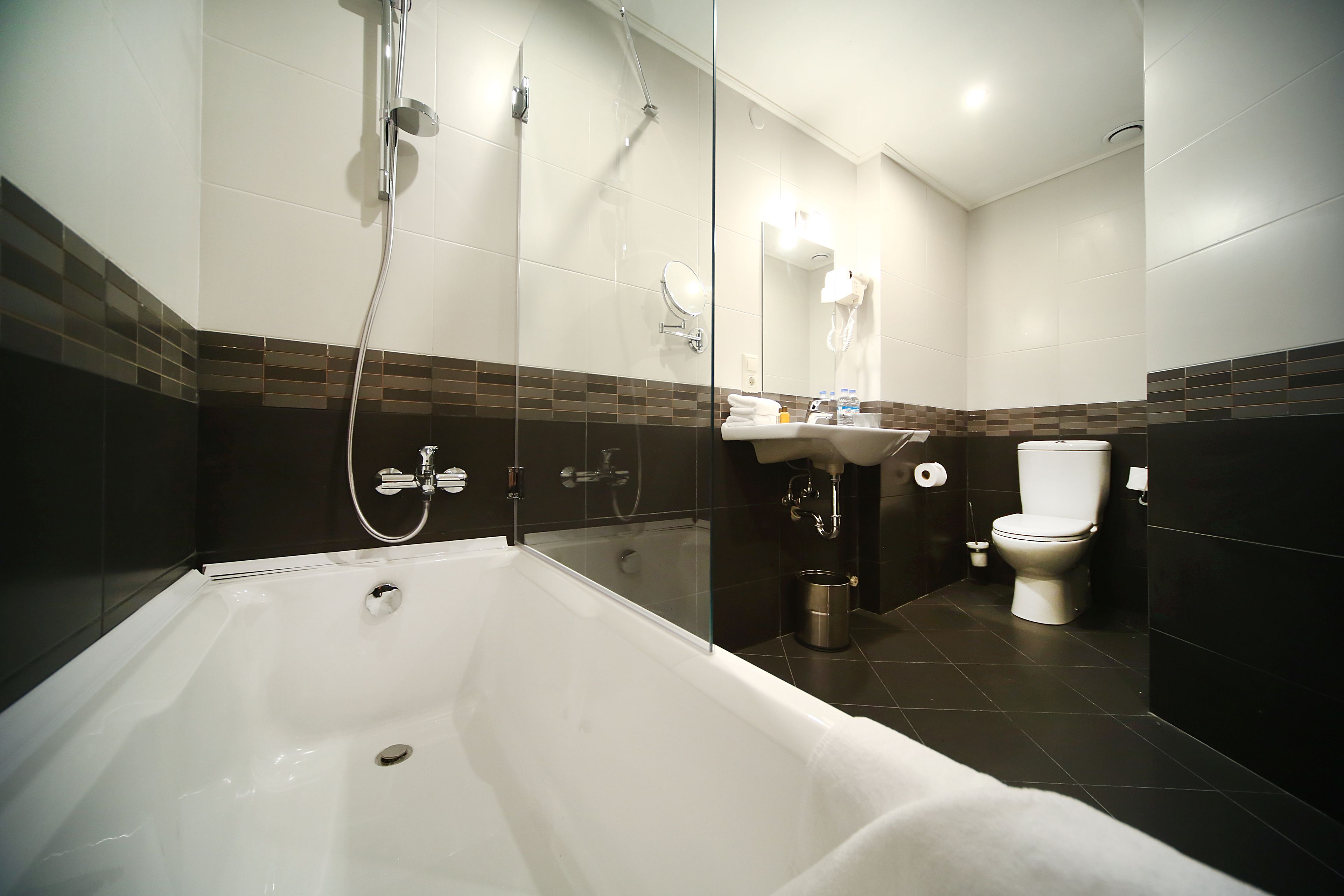 A modern bathroom with a bathtub, a toilet, and a sink.