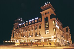 A large, multi-story hotel with a prominent sign reading "TIKALTUBO PLAZA".
