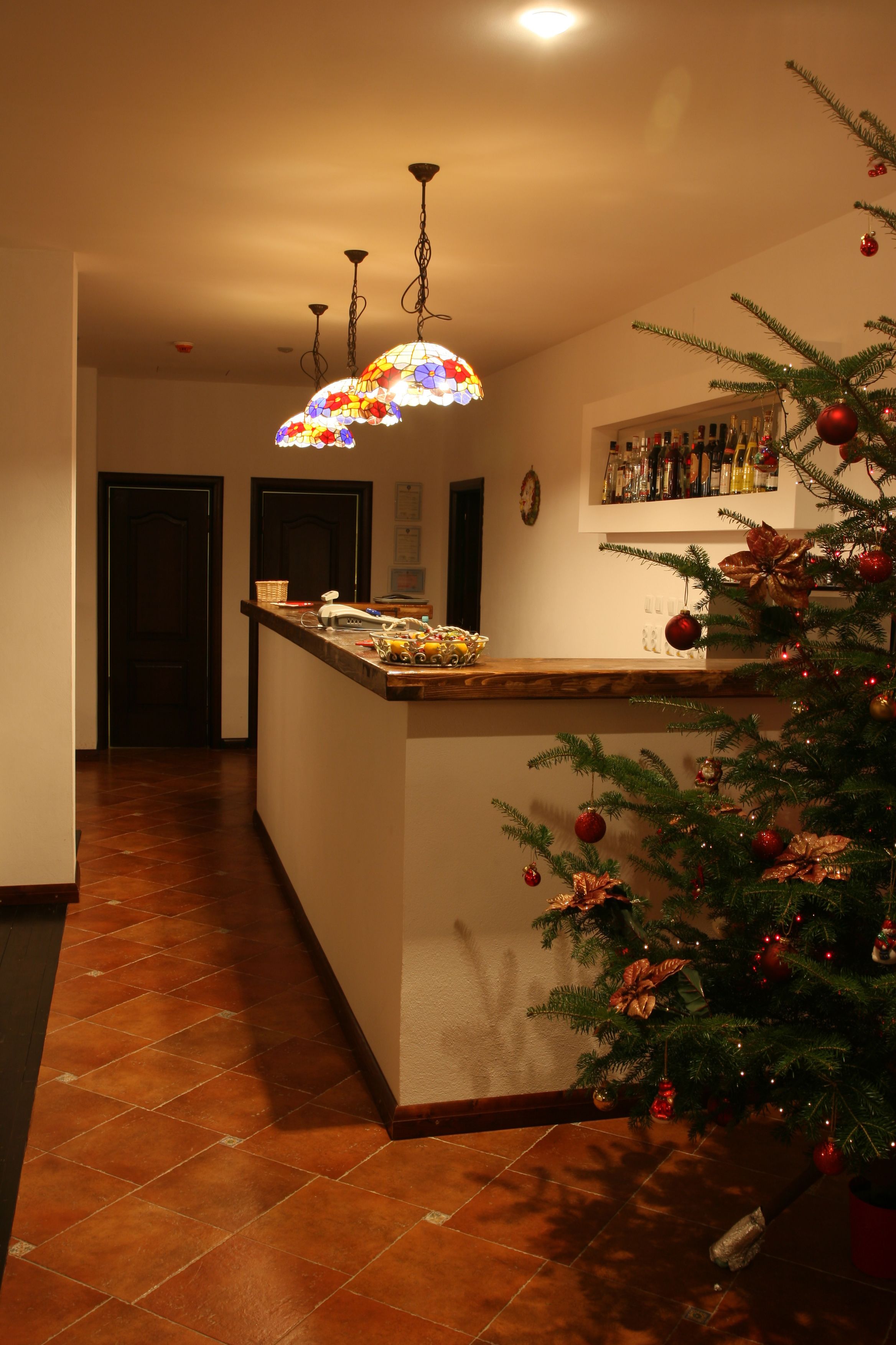 A kitchen with a wooden island, a Christmas tree, and a hanging light fixture.
