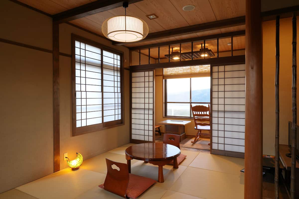 A traditional Japanese room with tatami flooring, a low wooden table, and sliding shoji doors.