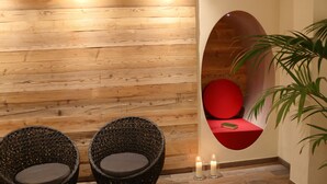 A room with two wicker chairs, a red cushioned bench, and a potted plant. - Haus Wiesengrund (Hallenberg)