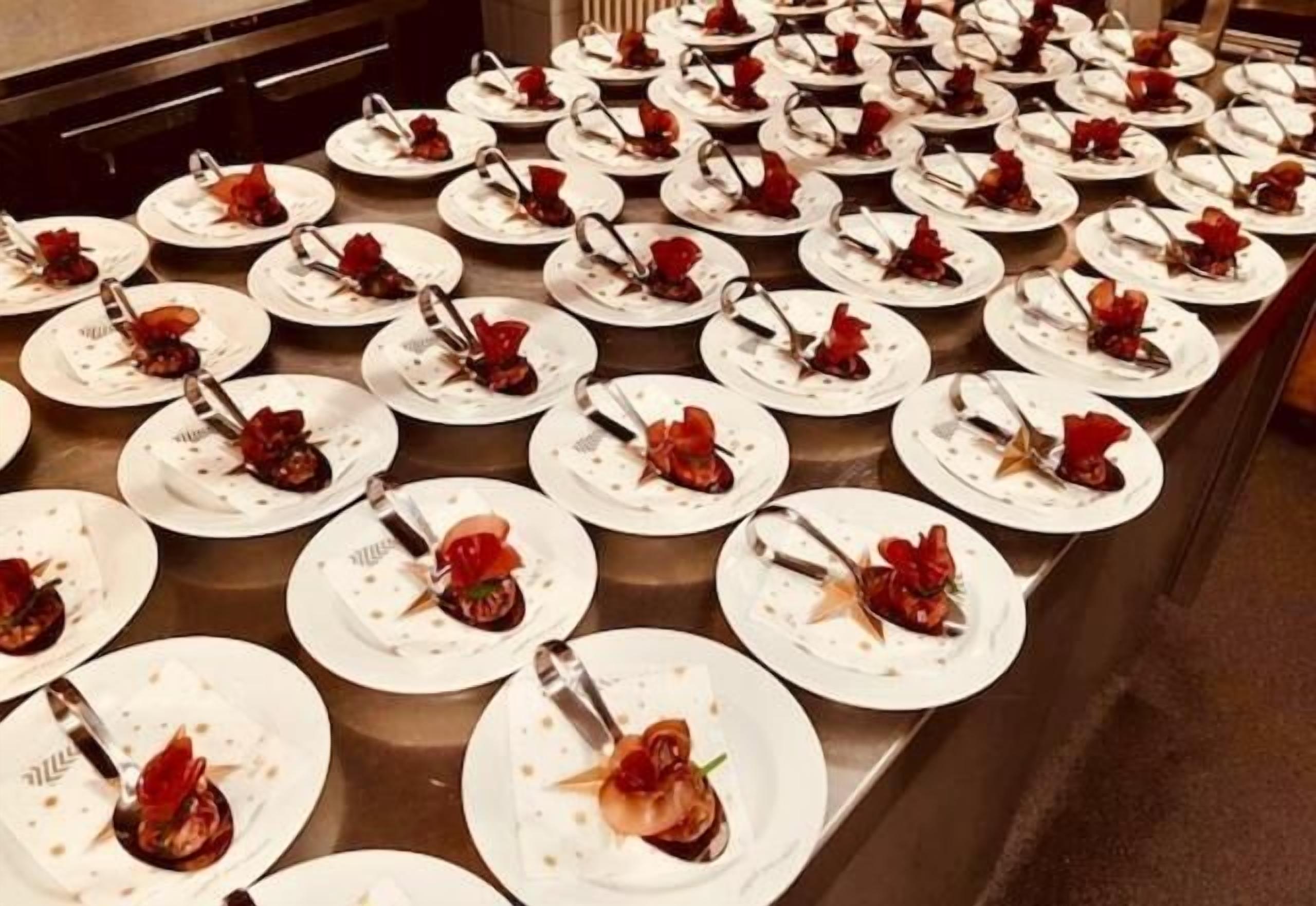 Una mesa de buffet con numerosas fuentes de comida, cada una con un tenedor y un adorno.