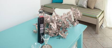A modern room with a teal table, a bed with a stone wall, and a hanging light fixture.