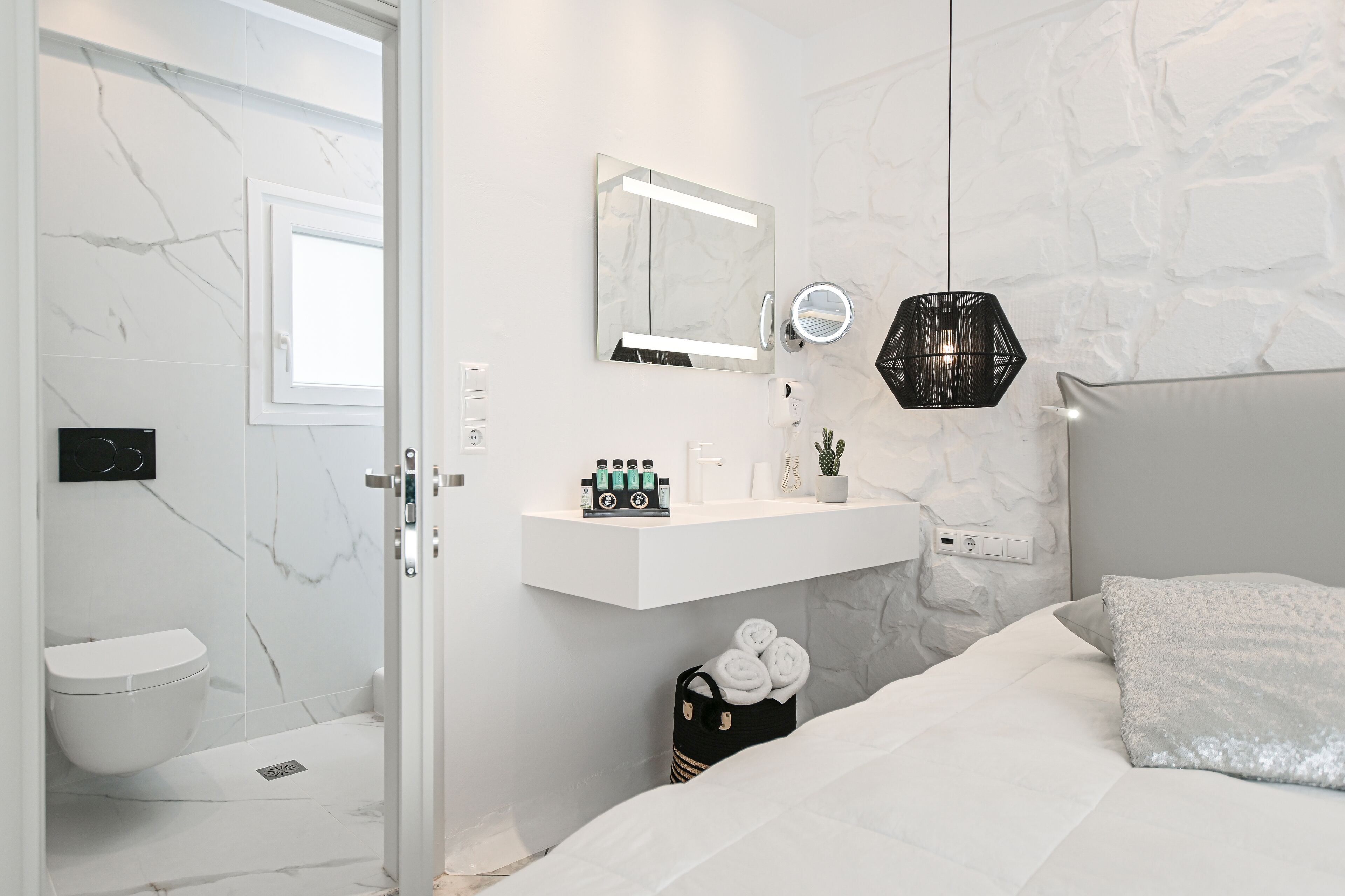 Un baño moderno con tocador blanco, un espejo y zona de ducha.