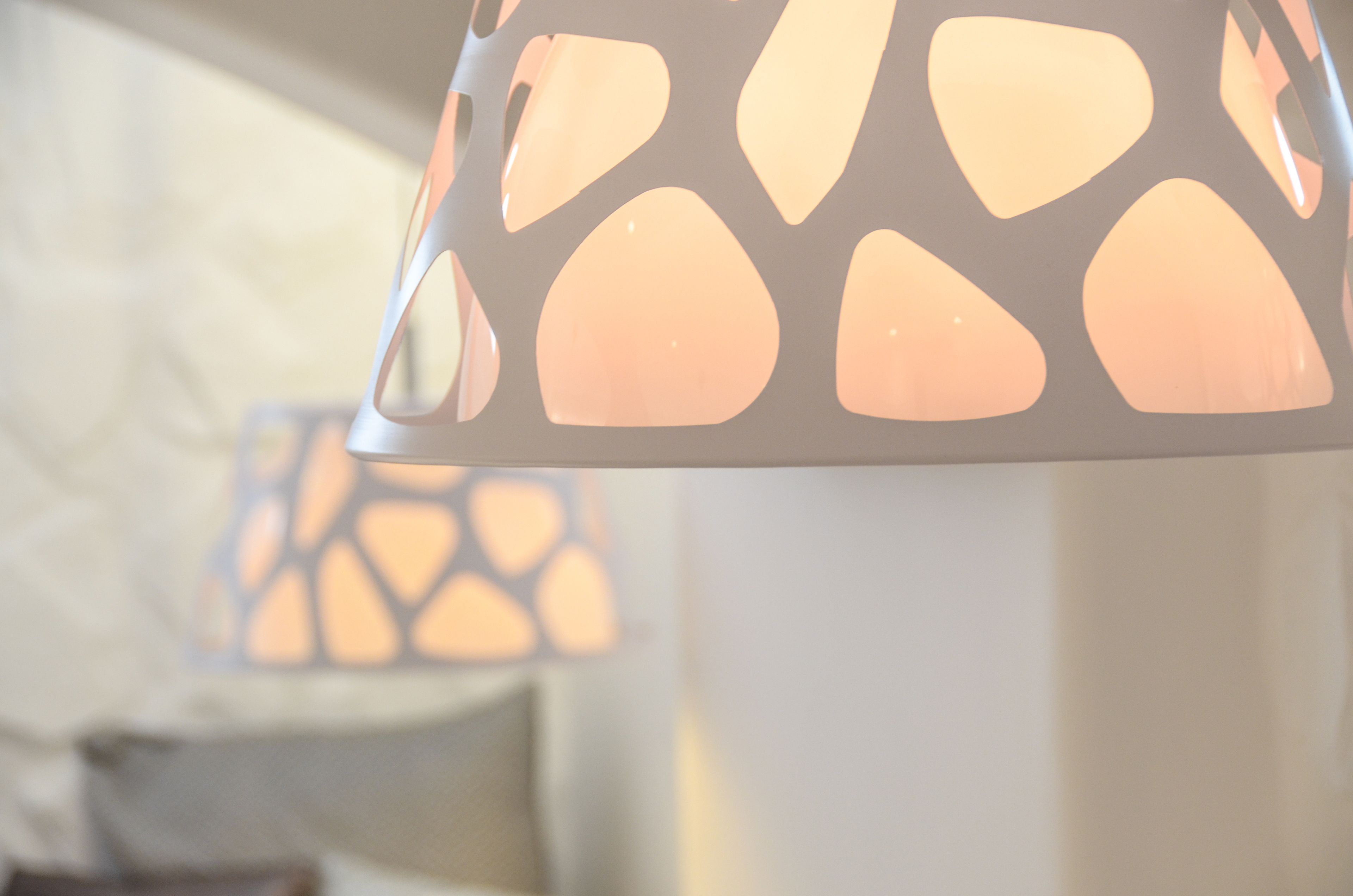 A close-up of a modern pendant light with a geometric pattern.