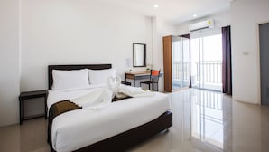 A hotel room with a large bed, a desk, a chair, a small plant, and a balcony with a view. - B2 Korat Boutique & Budget Hotel (Nakhon Ratchasima)
