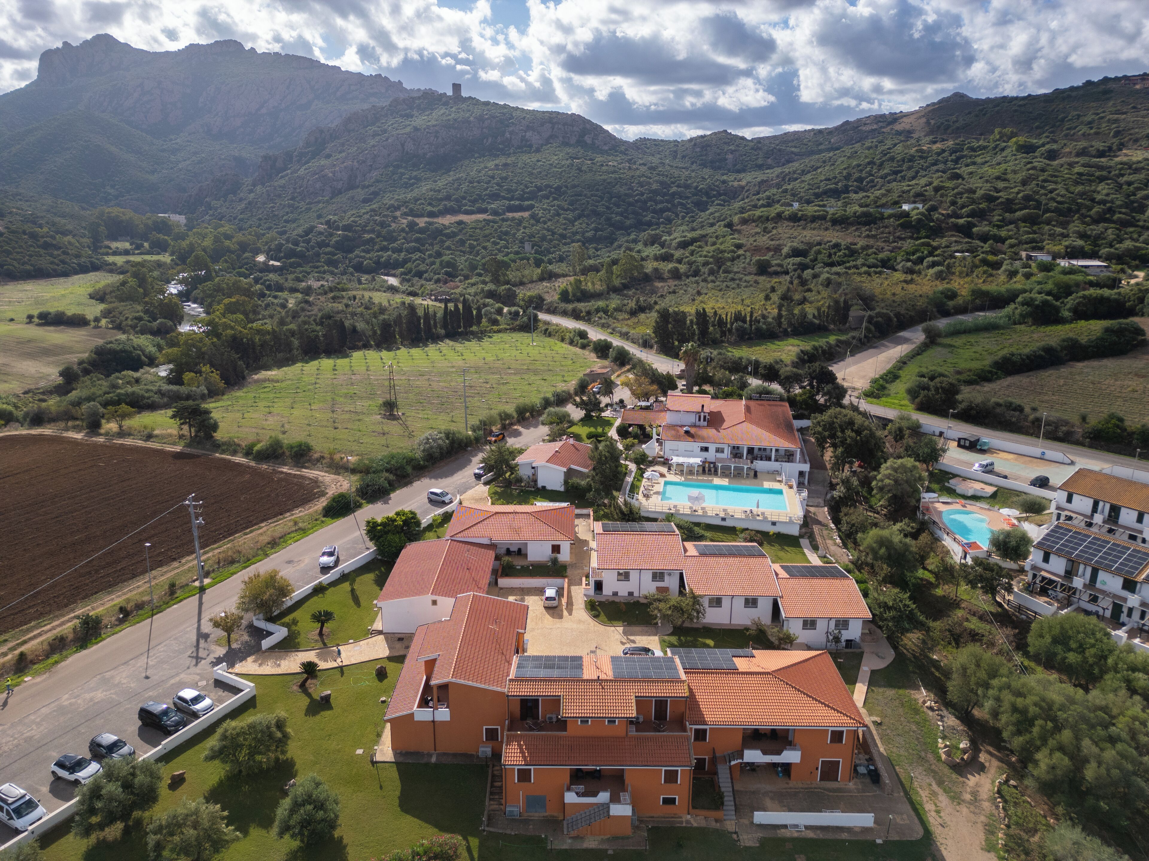 Um bairro residencial com casas, piscina e montanhas ao fundo.