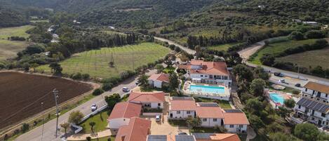 Zona residencial con casas, piscina y montañas al fondo.