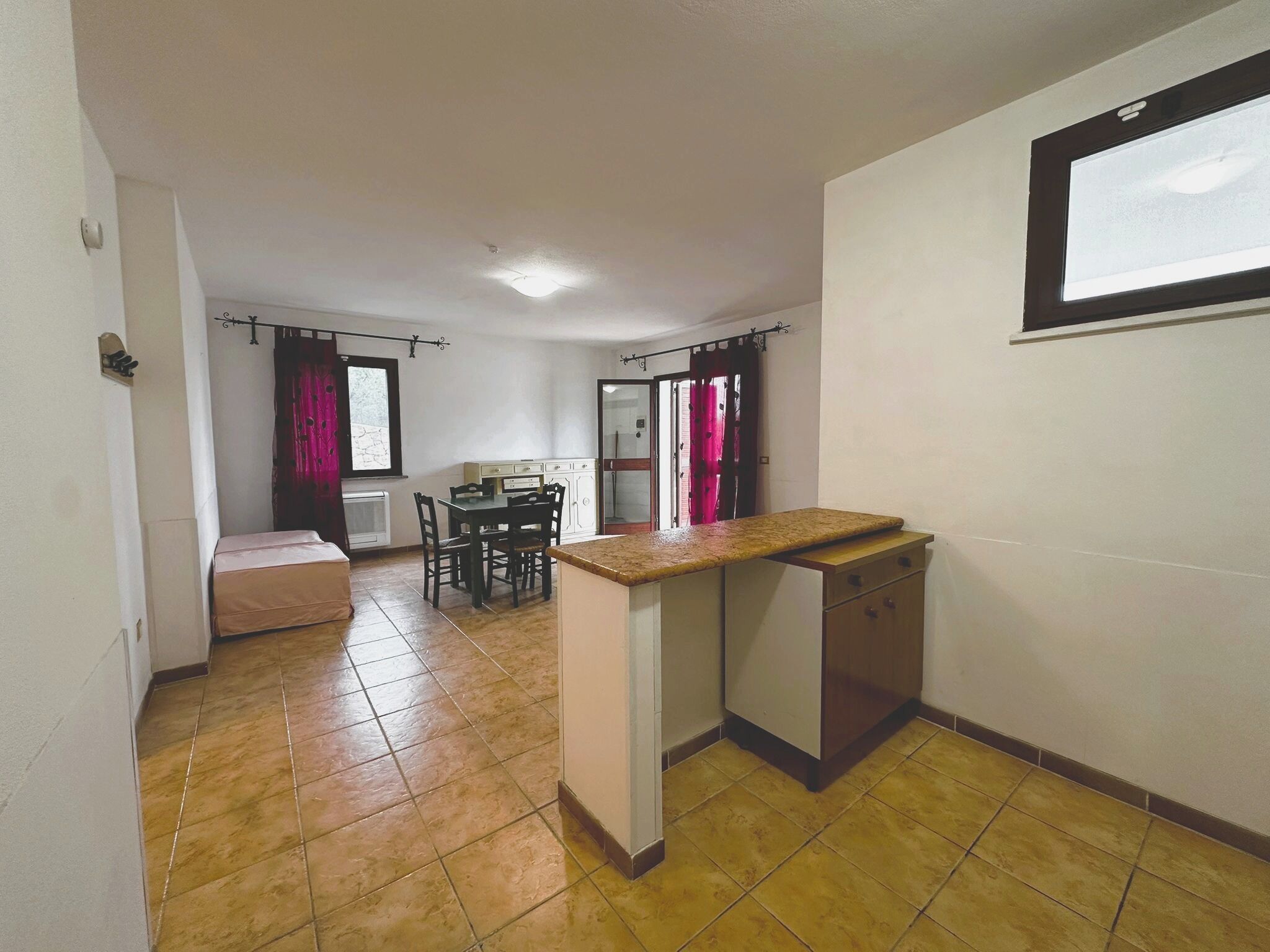 A compact kitchen with a small countertop and a dining area with a table and chairs.