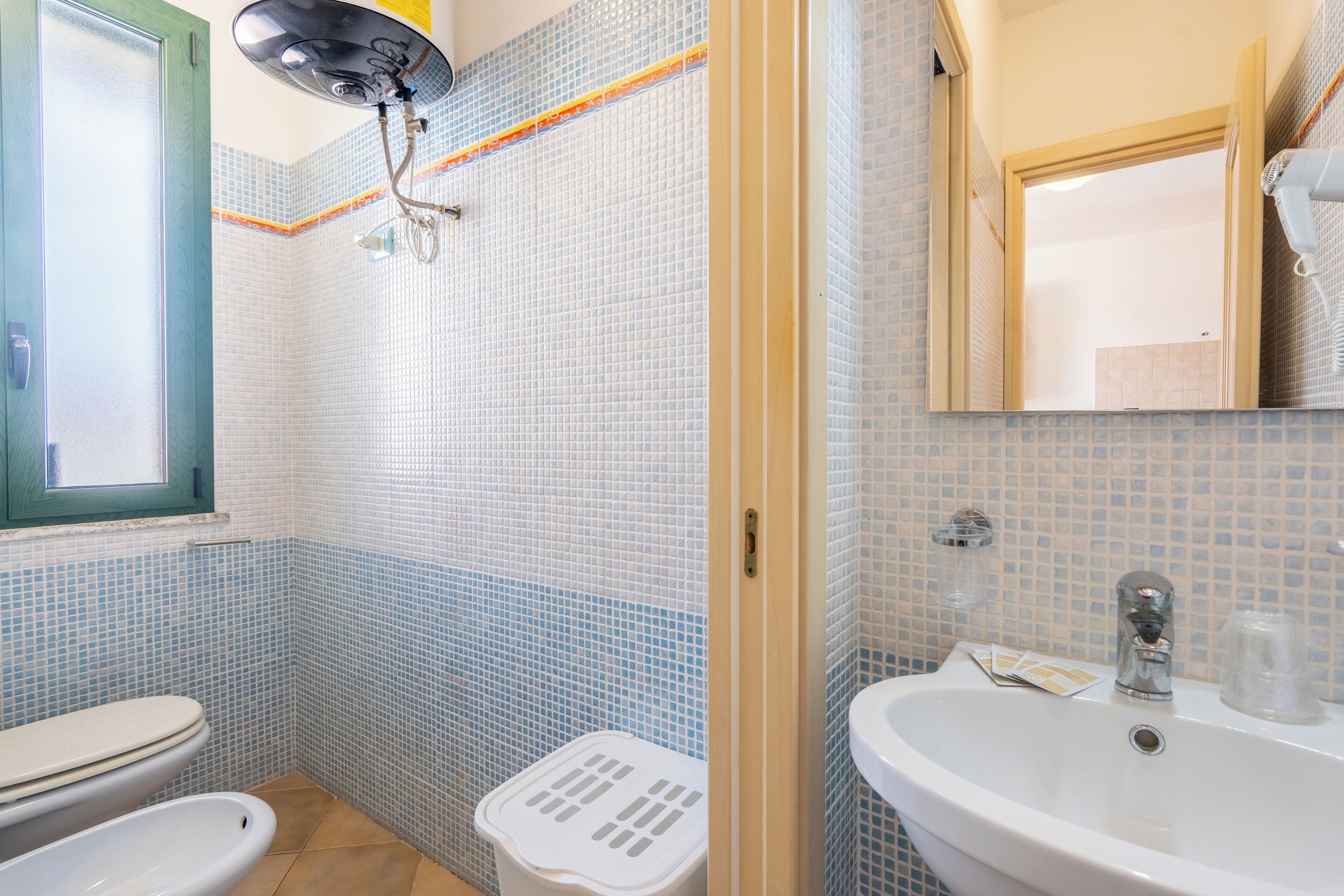 A bathroom with a toilet, bidet, and sink.