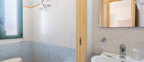 Un baño con inodoro, bidé y lavamanos.