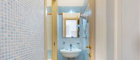 A bathroom with a sink, mirror, and towel rack.