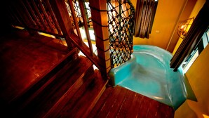 Una escalera de madera que conduce a una habitación con una bañera.